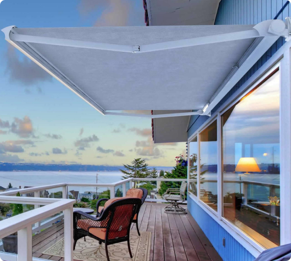 Una terrazza elegante con sedie e un ombrellone, che offre una vista panoramica sul mare al tramonto.